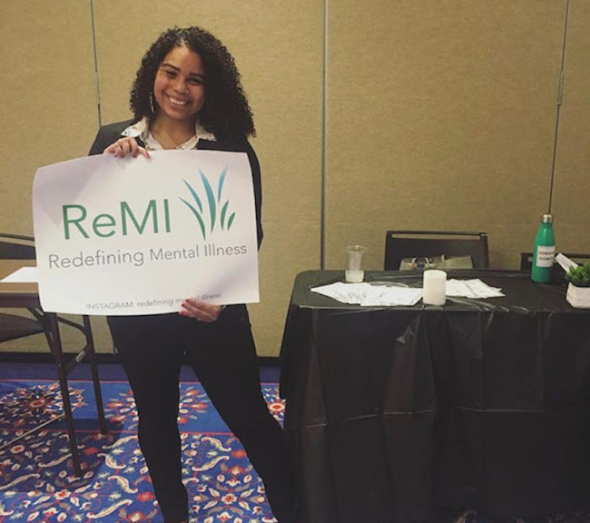 India with a poster from her organization Redefining Mental Illness (ReMI). Photo credit: India Angelique Luciano